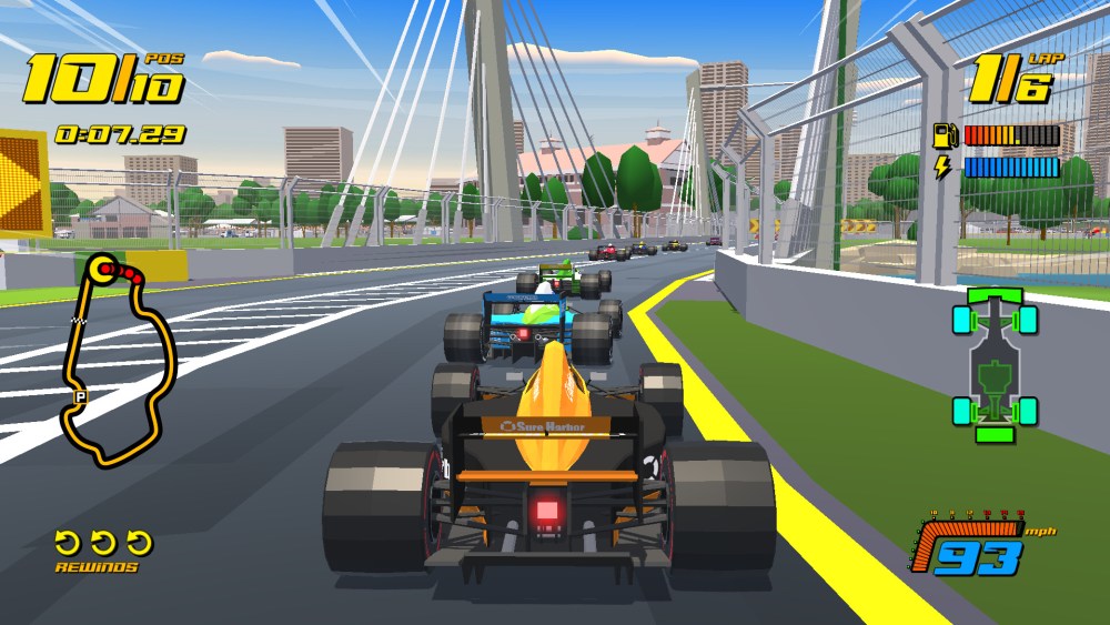 An orange racing car following a blue one round a corner in New Star GP. 