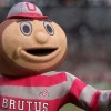 Ohio State's Brutus Buckeye Mascot standing with his hand extended out.